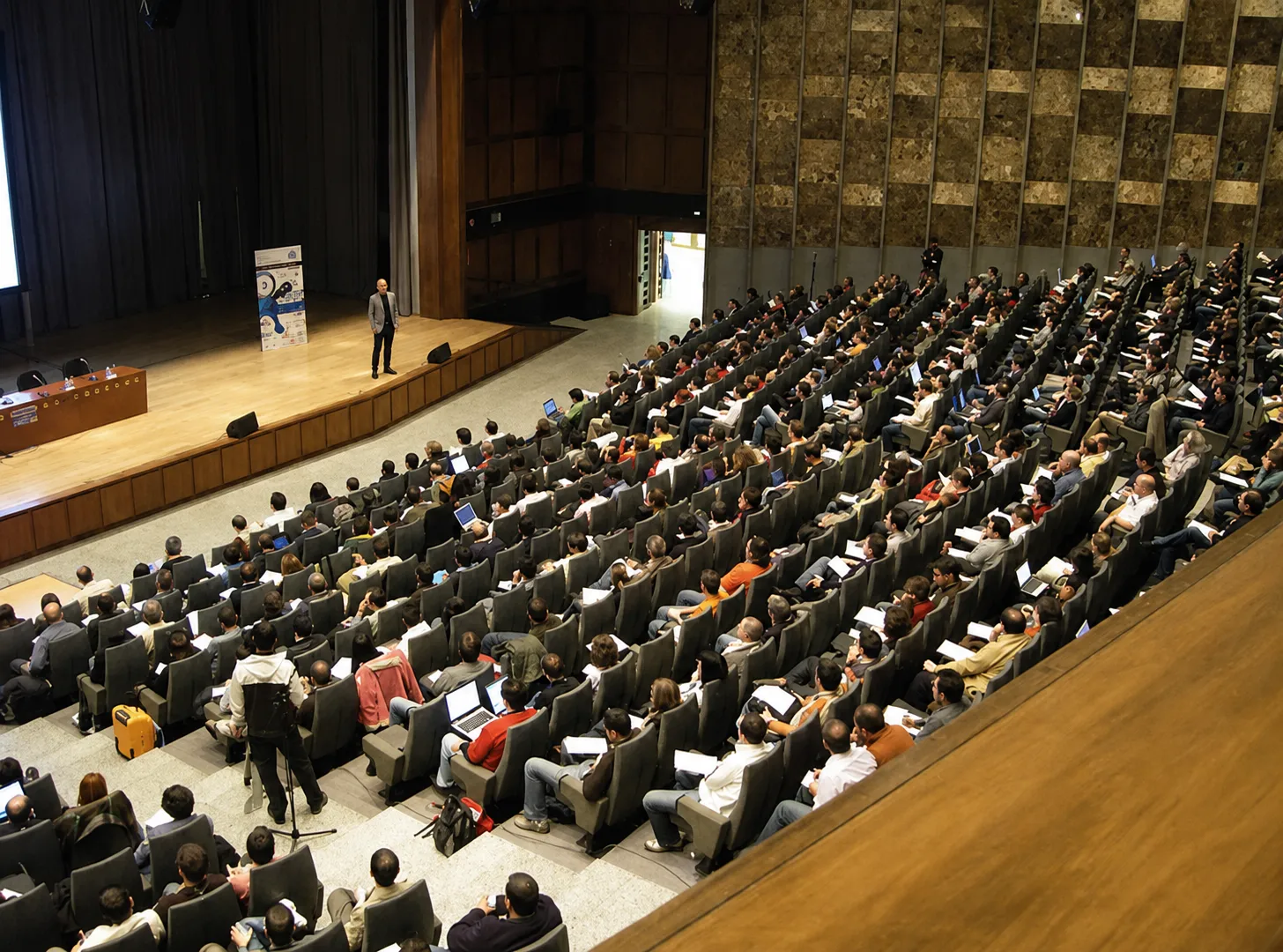 Carlos Castillo dando una ponencia ante un auditorio lleno en un evento financiero